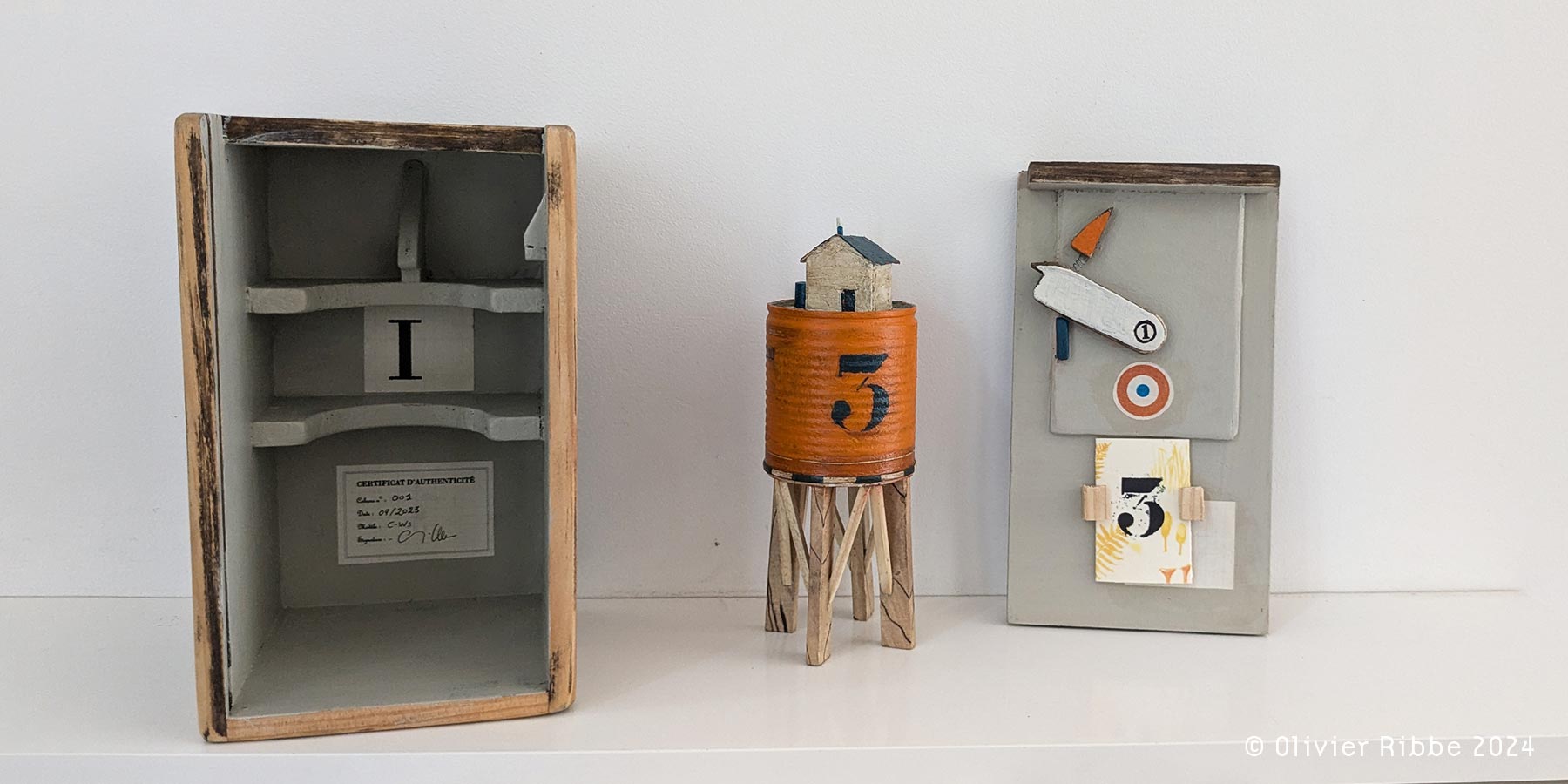 Photographie d'un objet d'art représentant une cabane et de son étui en bois